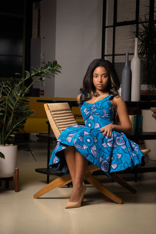 model sitting done wearing African print mini dress made with sky blue african wax fabric